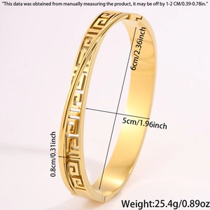 Detail view of gold stainless steel open bangle with intricate Greek Key cutout patterns