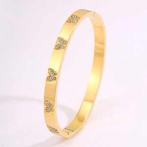 Detailopname van een gouden vlinderarmring met fonkelende ingelegde kristallen