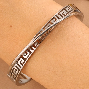 Detail showing the Greek Key pattern on the polished stainless steel crossover bangle