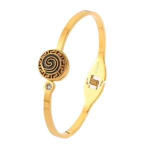 Golden stainless steel bangle with Greek key pattern and black spiral enamel centerpiece
