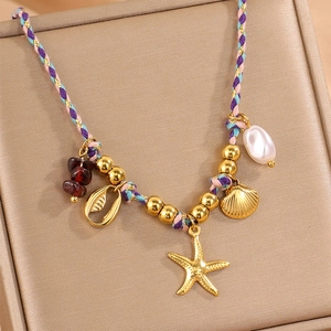 Détail d'un collier tressé coloré avec des étoiles de mer dorées et des perles marines
