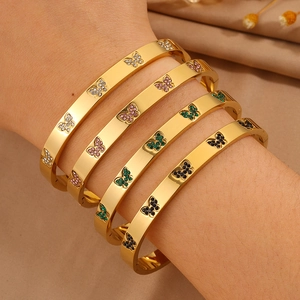 Gouden vlinder armbandenset met kleurrijke strass-steentjes op stoffen achtergrond