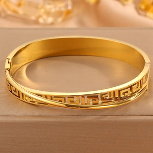 Detailed view of the gold Greca pattern hollow engraving on the stainless steel bangle