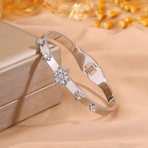 Detail of silver north star bangle with crystals on a golden jewelry gift box