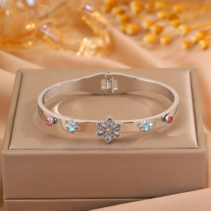 Detailed macro of silver four-leaf clover bangle with zircon inlays and spring clasp