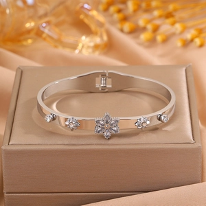 Macro detail of silver snowflake bangle with zircons on a golden jewelry box