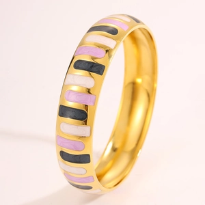 Detail of wide gold enamel bangle with pink white and black vertical stripe patterns