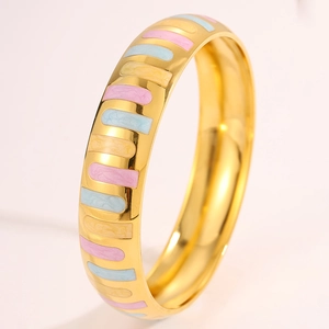 Detailed macro view of gold-plated wide cuff with colorful enamel rectangle patterns