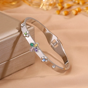 Close-up of silver steel bangle with colorful clover crystals and floral side details