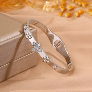 Detailed macro of silver stainless steel clover bracelet with sparkling zircons