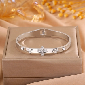 Macro shot of silver clover bracelet with sparkling cubic zirconia on golden silk box