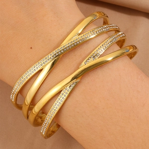 Bracciale rigido incrociato in acciaio inossidabile dorato con pavé di cristalli lucidi