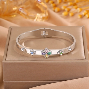 Macro shot of silver bangle with colorful zircon flower on a leather jewelry box