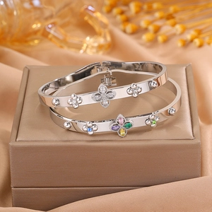 Silver stainless steel clover bracelets with diamonds and colorful gemstones in luxury display