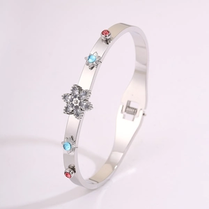 Macro shot of silver stainless steel bangle with colorful gemstones and floral detail