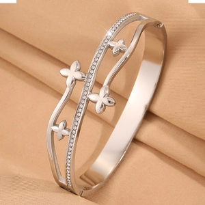 Vue macro d'un bracelet argenté multicouche avec motifs trèfles et pierres de zircon