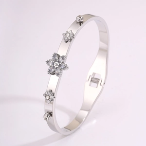 Macro shot of silver stainless steel starburst bangle with sparkling cubic zirconia flower