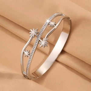 Détail du bracelet étoile argenté avec zircone sur fond de tissu en soie froissée