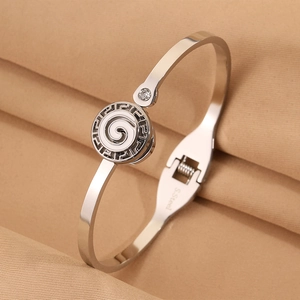 Macro shot of stainless steel bracelet with Greek key pattern and sparkling zircon stone