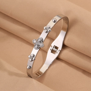 Detail of silver stainless steel bangle featuring zircon-encrusted clover flowers