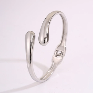 Détail du bracelet jonc argenté en acier inoxydable avec design goutte d'eau poli
