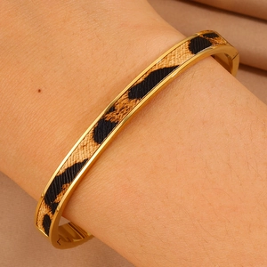 Nahaufnahme eines goldenen Edelstahl-Armreifs mit modischer Leopardenmuster-Einlage