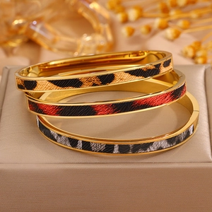 Nahaufnahme der goldenen Edelstahlarmreifen mit Leopardenmuster und Klappverschluss