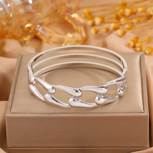Detail of silver hollow teardrop wide band cuff bracelet with high mirror polish finish