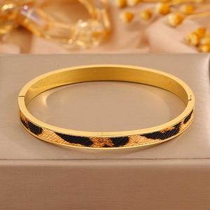Detailansicht des goldenen Armreifs mit Leopardenmuster auf einer edlen Schmuckschatulle