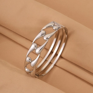 Macro view of polished silver stainless steel bracelet with cutout teardrop patterns