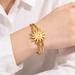 Smiling sun stainless steel open bangle in gold finish worn on a female wrist