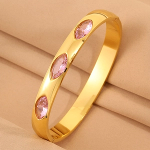 Detailaufnahme eines goldenen Edelstahlarmreifs mit drei marquise-rosa Edelsteinen