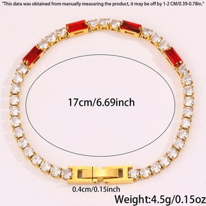 Dettaglio del bracciale tennis dorato con zirconi rossi e chiusura a scatto rifinita