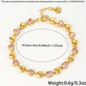 Detail of gold heart link bracelet with pink cubic zirconia and adjustable steel chain