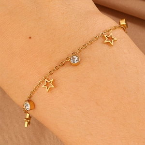 Detailed close-up of a gold titanium steel bracelet featuring star pendants and cubic zirconia
