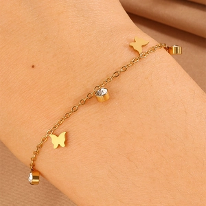 Detailed view of a gold-plated stainless steel butterfly bracelet with sparkling crystals
