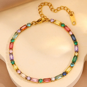 Dettaglio di pietre di zircone colorate su un bracciale in acciaio al titanio dorato