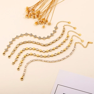 Detailed close-up of five gold plated titanium steel bracelets with zirconia and clover shapes