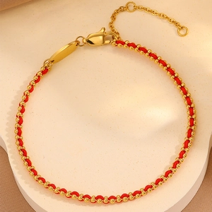 Macro detail of red woven rope bracelet with gold beads and lobster clasp closure