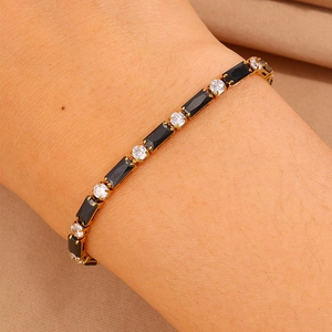 Dettaglio ravvicinato di un bracciale tennis con zirconi neri e chiari sul polso