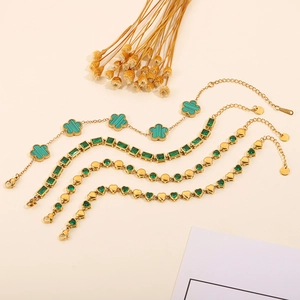Close-up of gold stainless steel bracelets with green malachite and emerald zircon charms