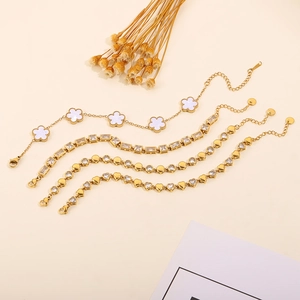 Detail of four-piece gold bracelet set featuring white enamel flower and zircon stones