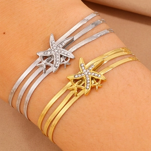 Détail des bracelets à trois couches en maille serpent avec des breloques étoile de mer
