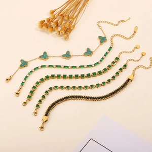 Detail of five gold titanium steel bracelets with green malachite and crystal accents