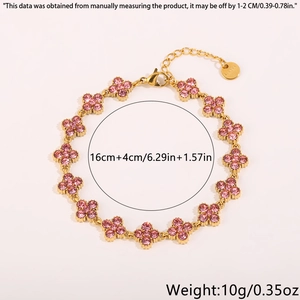 Macro detail of gold four-leaf clover bracelet with pink rhinestones and 16+4cm chain