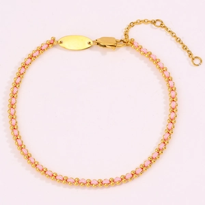 Macro detail of hand-woven pink cord bracelet with golden beads and adjustable lobster clasp