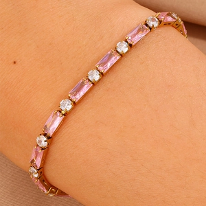 Dettaglio del bracciale tennis dorato con zirconi rosa rettangolari e tondi bianchi
