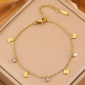 Elegant gold stainless steel butterfly bracelet with sparkling crystal charms on jewelry box