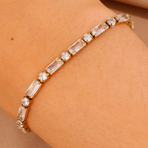 Dettaglio del bracciale tennis dorato con zirconi rettangolari e tondi sul polso