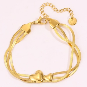 Détail du bracelet triple chaîne serpent dorée avec de jolis pendentifs en cœur